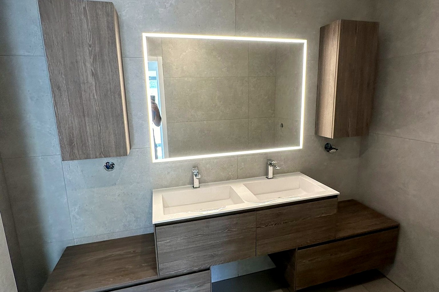 Salle de bain avec double vasque suspendue, miroir rétroéclairé et carrelage grand format