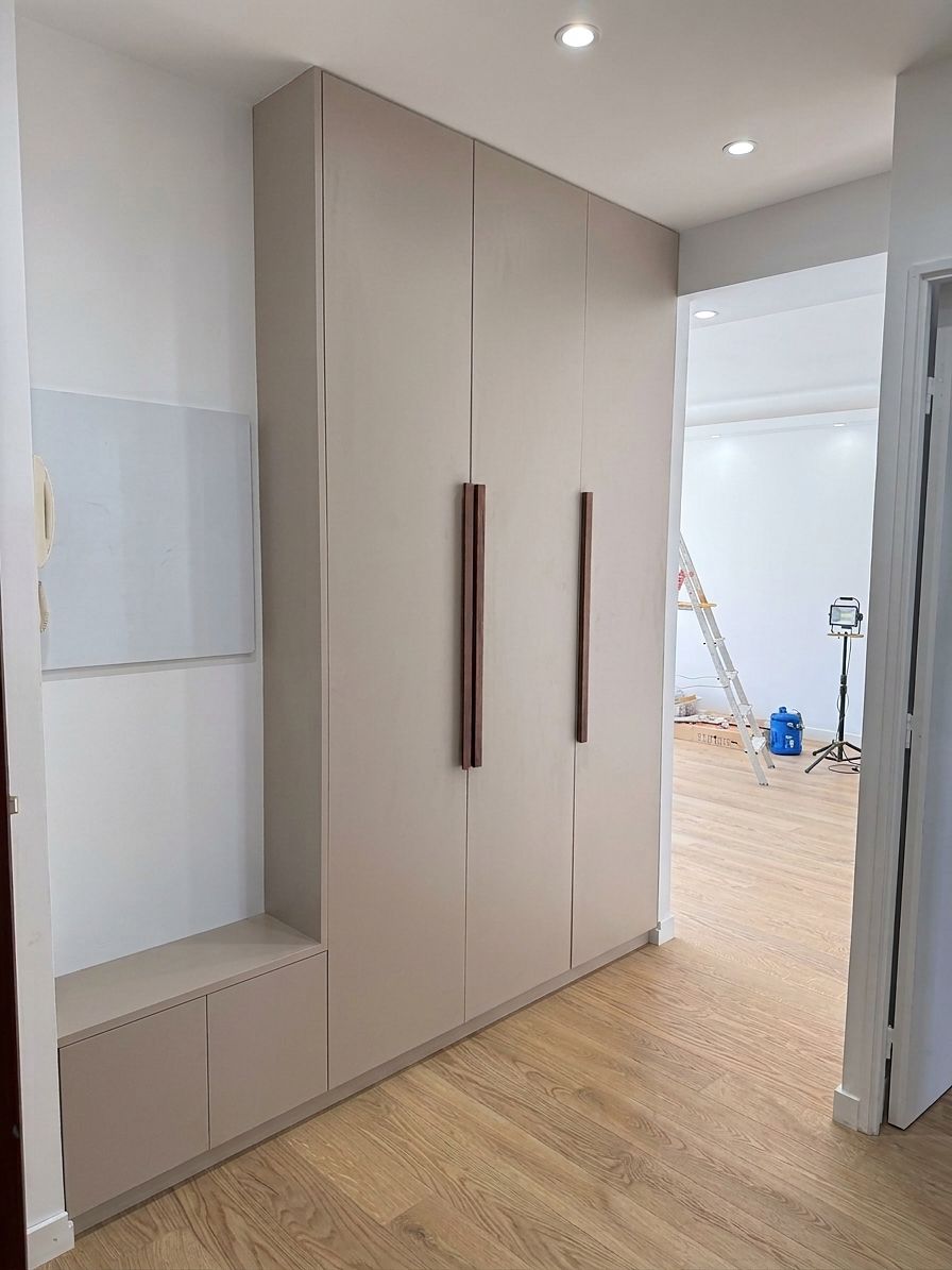 Meuble d'entrée sur mesure toute hauteur, façades laquées beige et poignées en noyer, avec banc intégré